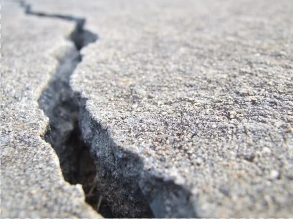 Close-up look at wide crack in concrete sidewalk